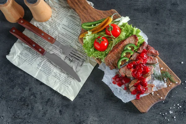 Filete en rodajas servido con salsa de arándanos y verduras sobre tabla de madera —  Fotos de Stock