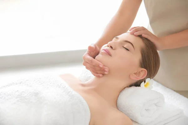 Młoda kobieta korzystających z masażu twarzy w salonie spa — Zdjęcie stockowe