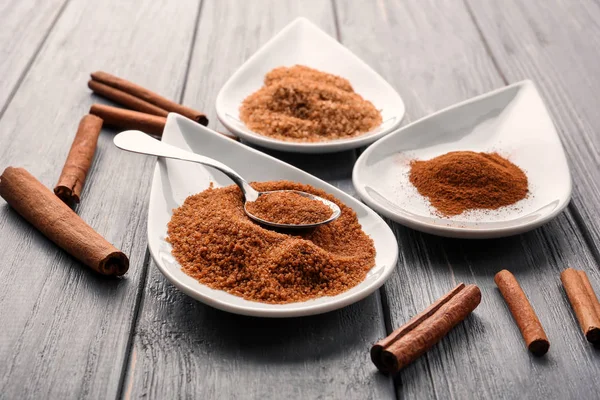 Tarçınlı şeker ve toz ahşap arka plan üzerinde plakalı kompozisyon