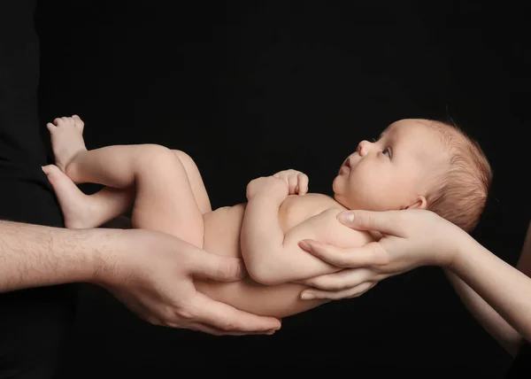 Genitori che tengono il neonato su sfondo nero, primo piano — Foto Stock