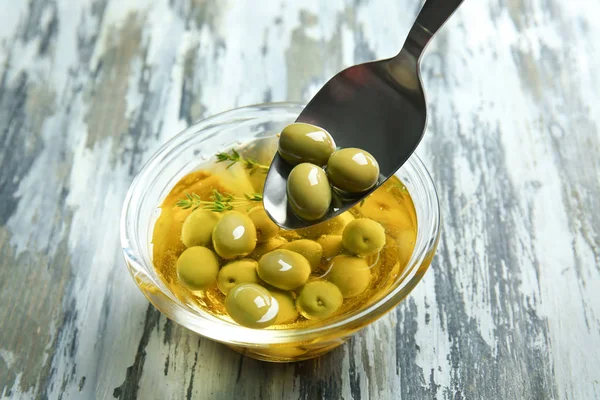 Kaşık ve petrol ve zeytin ahşap masa üzerinde pişirme ile kase