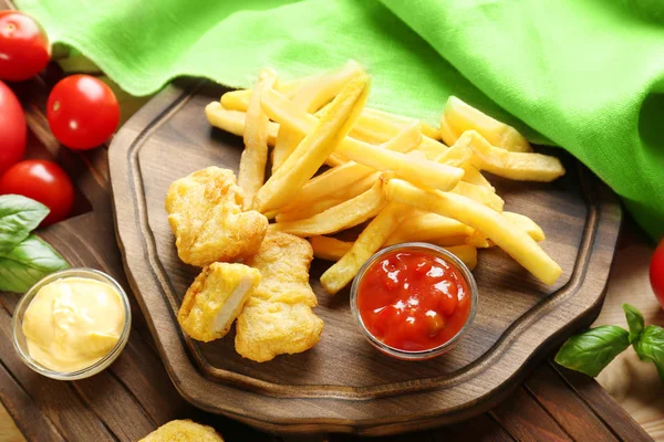 Smakelijke nuggets, frietjes en sauzen — Stockfoto