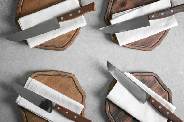 Couteaux avec serviettes et planches en bois — Photo