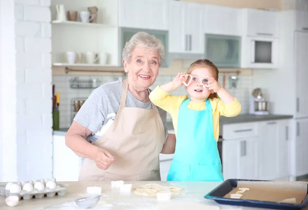 Klein meisje en grootmoeder op keuken — Stockfoto