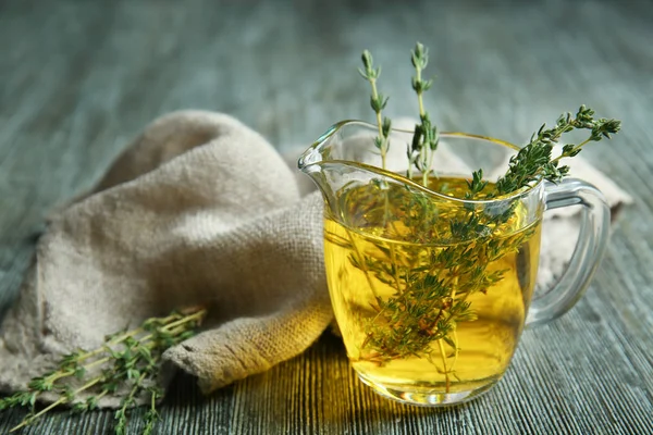 Jug with cooking oil and thyme — Stock Photo, Image