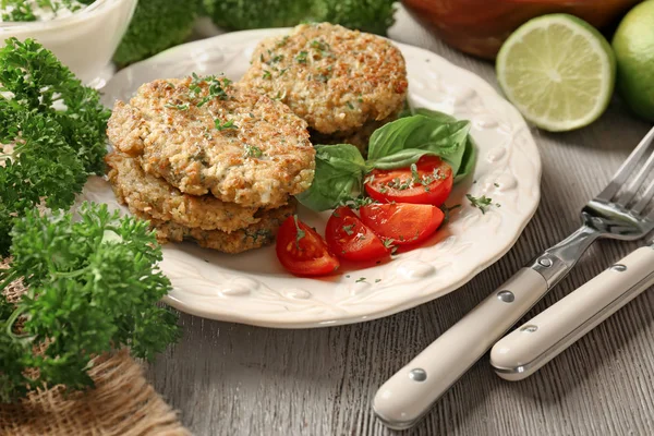 Panqueques de brócoli servidos con tomates cherry y hojas de albahaca en plato blanco —  Fotos de Stock