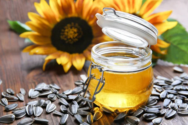 Jar with cooking oil and seeds — Stock Photo, Image