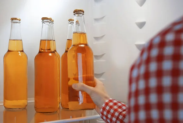 Woman taking a bottle of lemonade from open fridge — Stock Photo, Image