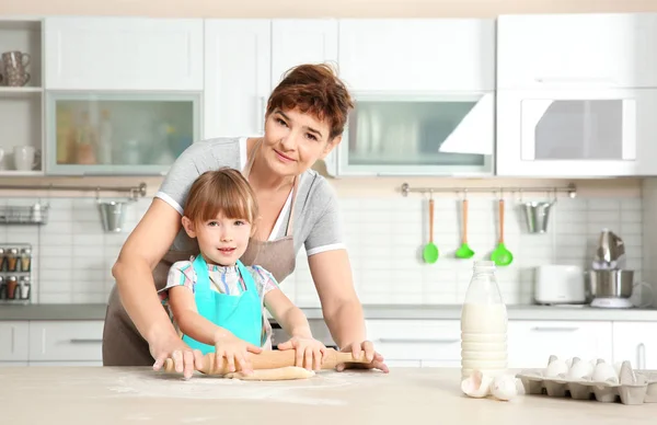 Little girl and grandmother on kitchen — Stock Photo, Image