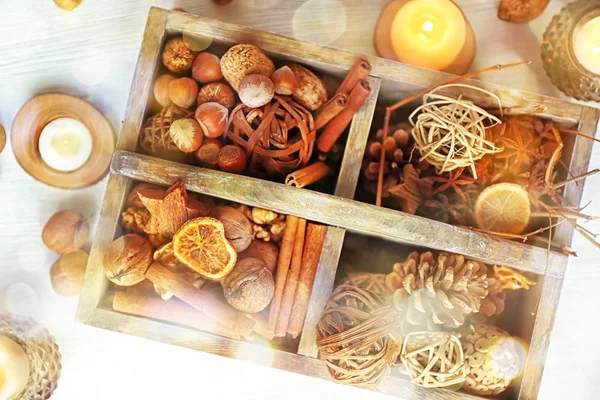 Houten kist met kerst decoratie, noten en specerijen op de lichte achtergrond — Stockfoto