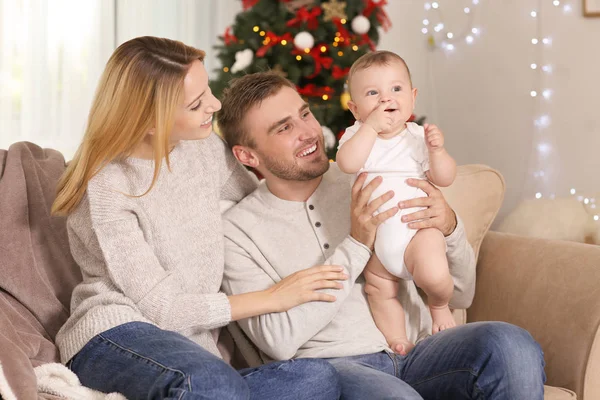 Счастливые родители с ребенком в украшенной комнате на Рождество — стоковое фото