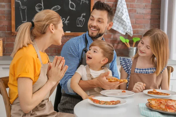 Family eating yummy pizza together in kitchen. Cooking classes concept — Stock Photo, Image