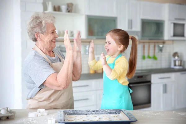 Klein meisje en grootmoeder op keuken — Stockfoto