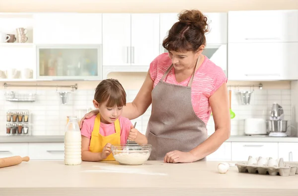 Liten flicka och mormor på kök — Stockfoto