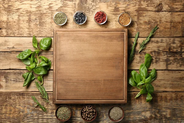 Samenstelling met houten plank, specerijen en kruiden op tafel — Stockfoto