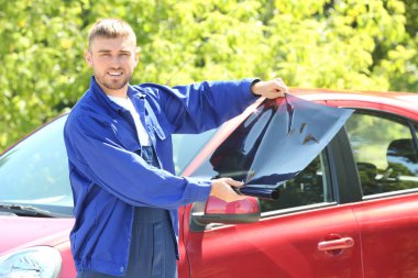 İşçi renklendirme folyo araç penceresi üzerine uygulamak hazırlanıyor