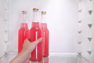 Bir şişe açık buzdolabı gelen çilek limonata alarak kadın