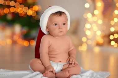 Bulanık Noel ışıkları karşı katta oturan Santa şapka içinde şirin bebek