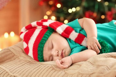 Karşı uyuyan sevimli bebek Noel ışıkları arka plan bulanık