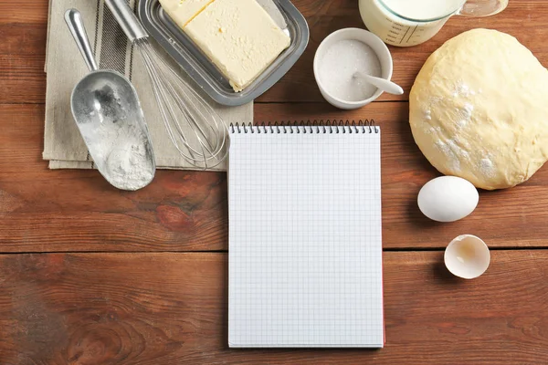 Quaderno e pasta cruda con ingredienti sul tavolo della cucina. Corso di cucina concetto — Foto Stock