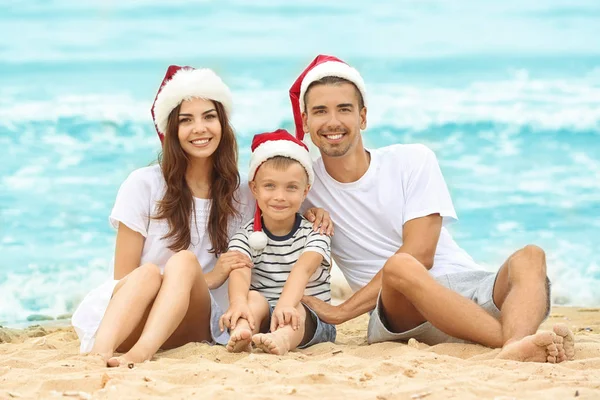 Pareja joven con lindo chico en la playa. Concepto de Navidad —  Fotos de Stock