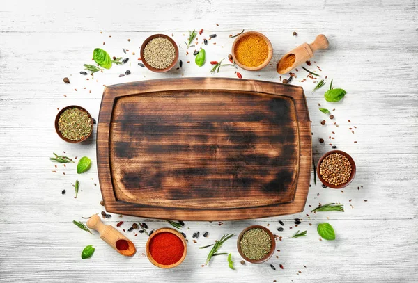 Composition with wooden board, spices and herbs on table — Stock Photo, Image