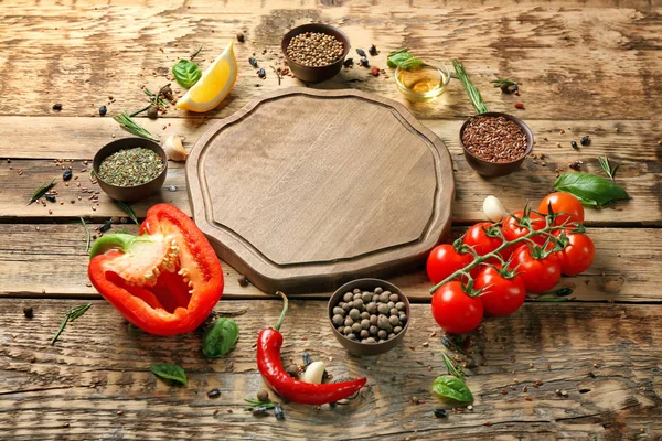 Složení s dřevěnou deskou a ingrediencemi na vaření na stole — Stock fotografie