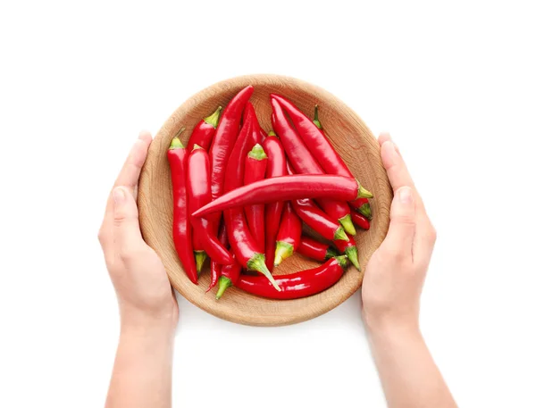 Woman's hands holding wooden plate with red chili peppers isolated on white — Stock Photo, Image