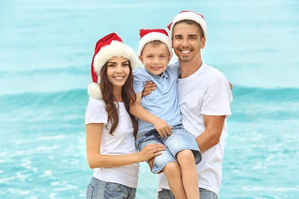 Young couple with boy on beach. Christmas concept — Stock Photo, Image