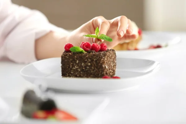 Femme chef décorant dessert savoureux dans la cuisine, gros plan — Photo