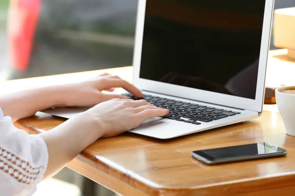 Молодая женщина работает с ноутбуком за столом — стоковое фото
