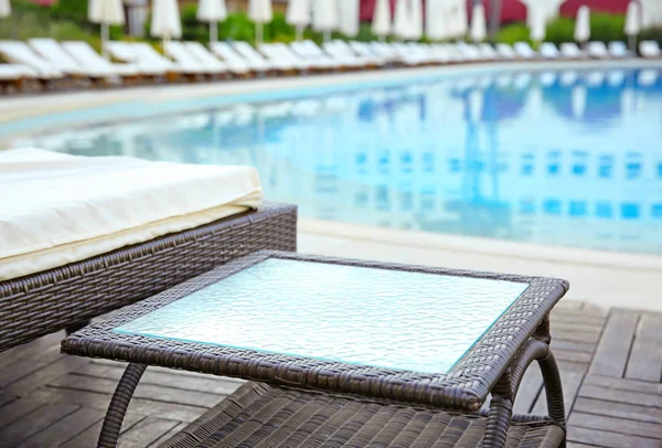 Rattan table near swimming pool — Stock Photo, Image