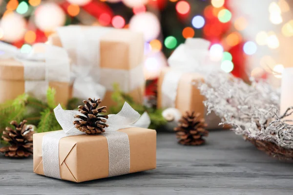 Gift box and Christmas decorations on table against blurred lights — Stock Photo, Image