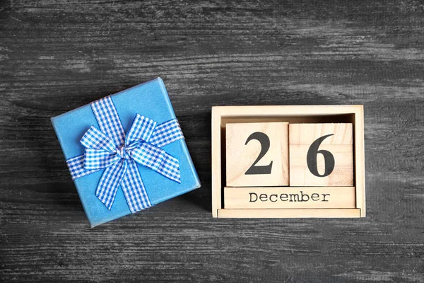 カレンダー日付とギフト ボックスの木製の背景で。クリスマス コンセプト — ストック写真