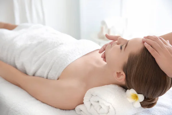 Mujer joven disfrutando del masaje facial en el salón de spa —  Fotos de Stock