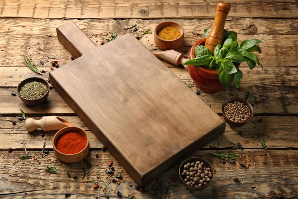 Composición con tabla de cortar, especias y hierbas sobre fondo de madera — Foto de Stock