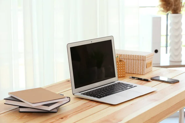 Ahşap masa üzerinde modern dizüstü bilgisayar ile işyeri — Stok fotoğraf