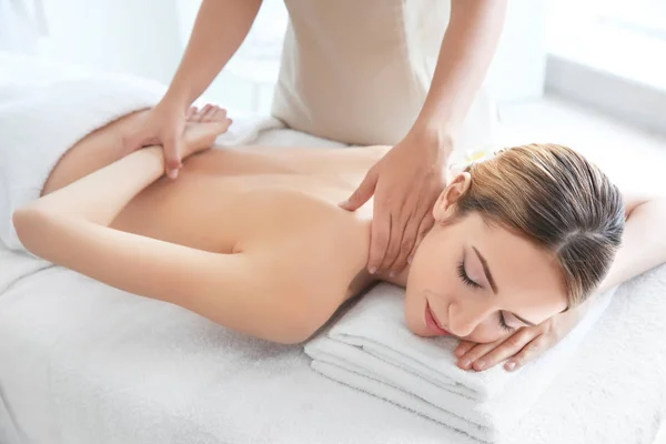 Junge schöne Frau mit Massage im Wellness-Salon — Stockfoto