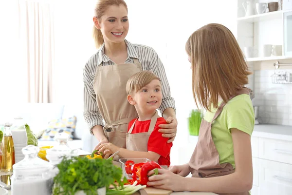 Mother and children making meal together in kitchen. Cooking classes concept — Stock Photo, Image