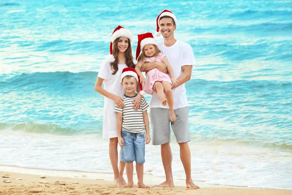 Unga par med barn på stranden. Jul-konceptet — Stockfoto