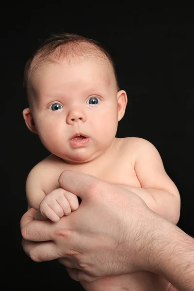 Padre che tiene il neonato su sfondo nero — Foto Stock