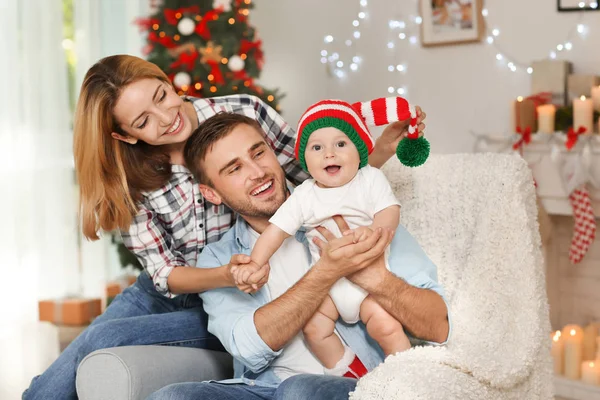 Padres felices con bebé en habitación decorada para Navidad —  Fotos de Stock