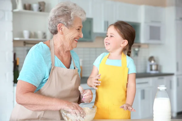 Little girl and grandmother on kitchen — Stock Photo, Image