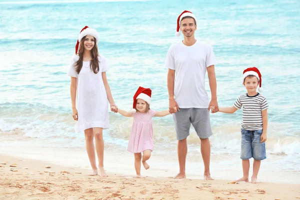 Unga par med barn på stranden. Jul-konceptet — Stockfoto