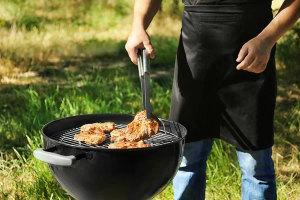 Uomo che prepara bistecche barbecue — Foto Stock