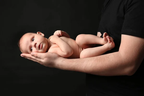 Otec držel novorozence na černém pozadí — Stock fotografie