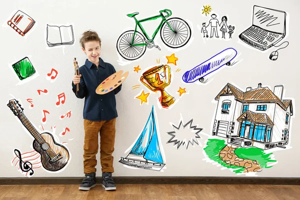 Sevimli küçük sanatçı ve duvar arka plan üzerinde farklı çizimler