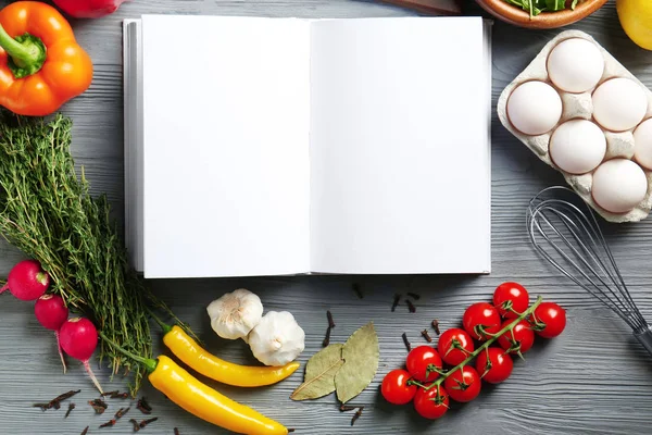 Caderno aberto e legumes na mesa da cozinha. Conceito de aulas de culinária — Fotografia de Stock