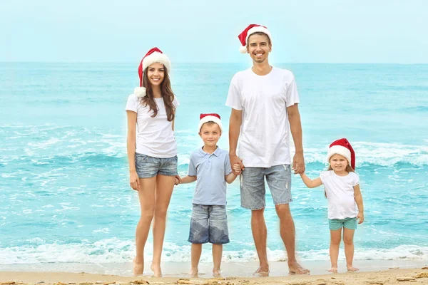 Młoda para z dziećmi na plaży. Boże Narodzenie koncepcja — Zdjęcie stockowe