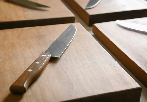 Coltelli e tavole di legno sul tavolo della cucina. Corso di cucina concetto — Foto Stock